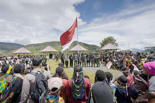 Bersama Masyarakat, Satgas Yonif 715/Motuliato dan Apkam Puncak Jaya Kibarkan Bendera Merah Putih Raksasa di Momen Tanggal 1 Mei 2025