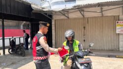Polda Sumsel Bagikan Bendera Merah Putih Kepada Masyarakat Palembang Menyambut Hut Kemerdekaan RI Ke-80