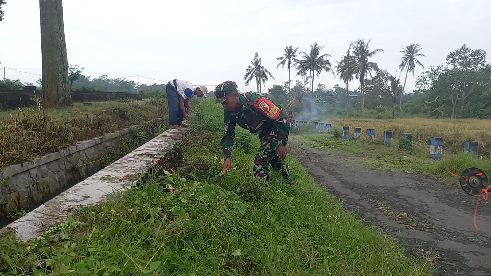 Bersihkan Bahu Jalan, Babinsa Pasirharjo Kerja Bakti Bersama Warga Demi Keindahan Lingkungan